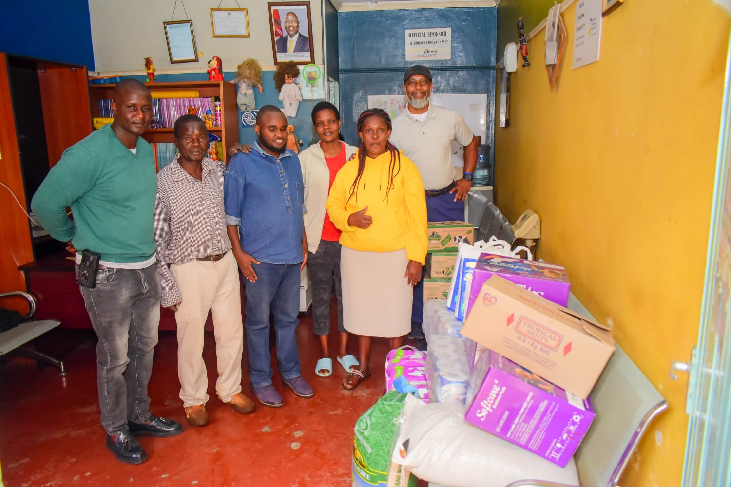 Community partners standing beside supplies prepared for an inclusive school