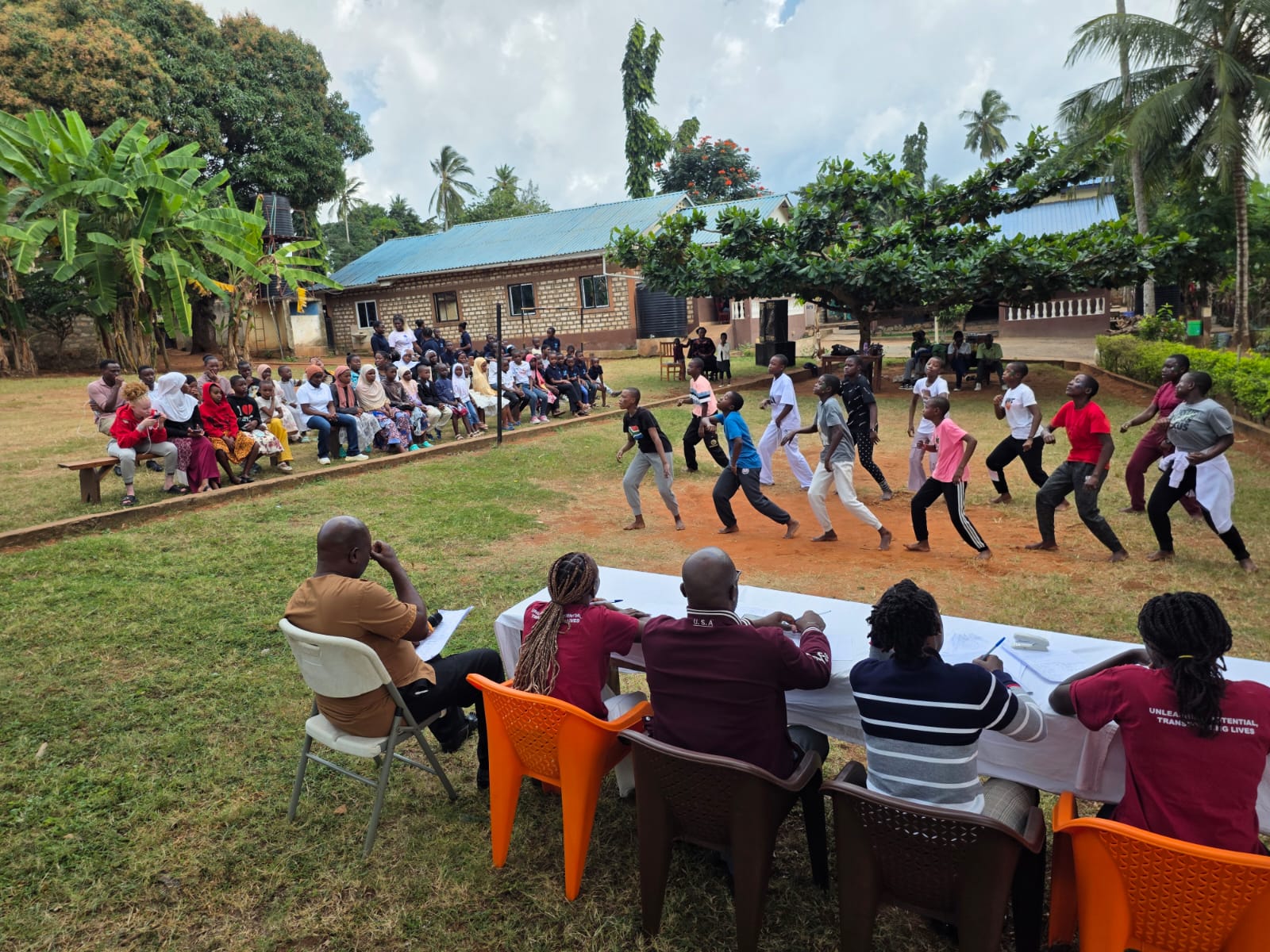 Children performing together outdoors during an Amani Gold youth festival
